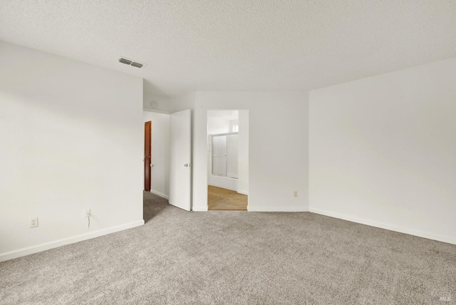 carpeted spare room featuring a textured ceiling