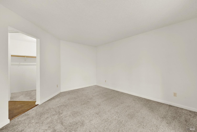 carpeted empty room with a textured ceiling