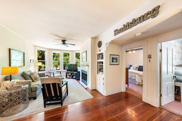 living room with ceiling fan and dark hardwood / wood-style flooring