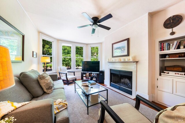 living room with ceiling fan and built in features