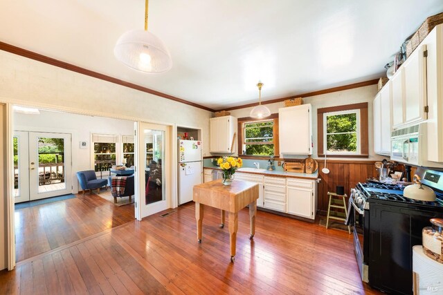 kitchen featuring pendant lighting, white appliances, dark hardwood / wood-style floors, and white cabinets