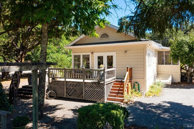 bungalow featuring a wooden deck and a sunroom