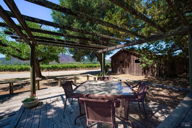 view of patio / terrace featuring a deck with mountain view, an outdoor structure, and a pergola