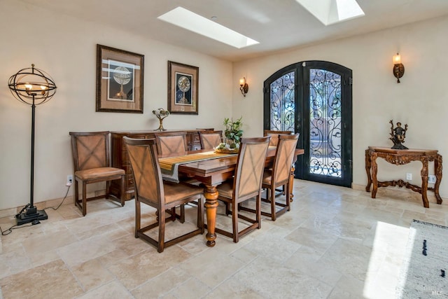 dining room featuring a skylight and french doors