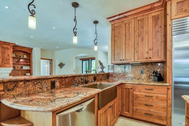 kitchen featuring pendant lighting, light stone counters, stainless steel appliances, and kitchen peninsula