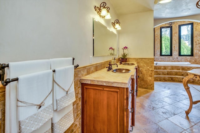 bathroom featuring vanity and tiled bath