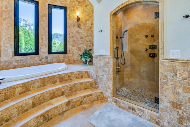 bathroom featuring separate shower and tub and tile walls