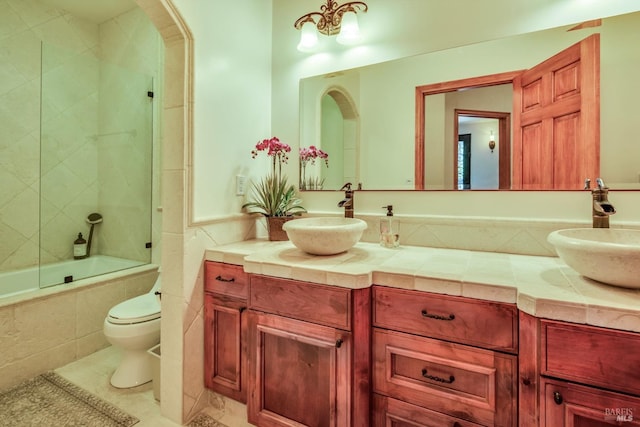 full bathroom featuring tiled shower / bath combo, vanity, tile patterned floors, and toilet