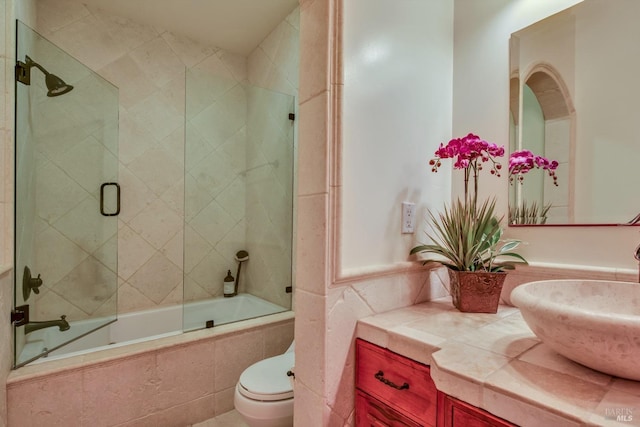 full bathroom with vanity, toilet, and combined bath / shower with glass door