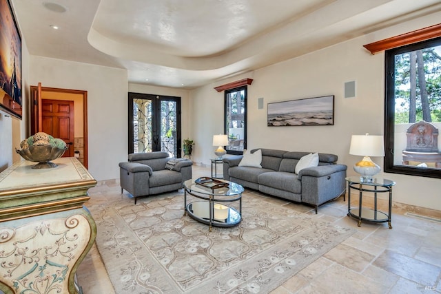 living room with french doors and a raised ceiling