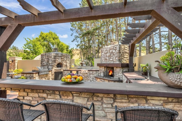 view of patio with area for grilling, grilling area, and a stone fireplace