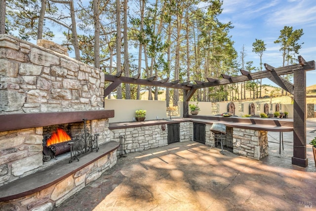 view of patio / terrace with an outdoor bar and an outdoor stone fireplace