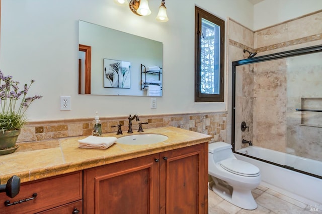 full bathroom featuring tile patterned floors, toilet, shower / bath combination with glass door, tile walls, and vanity