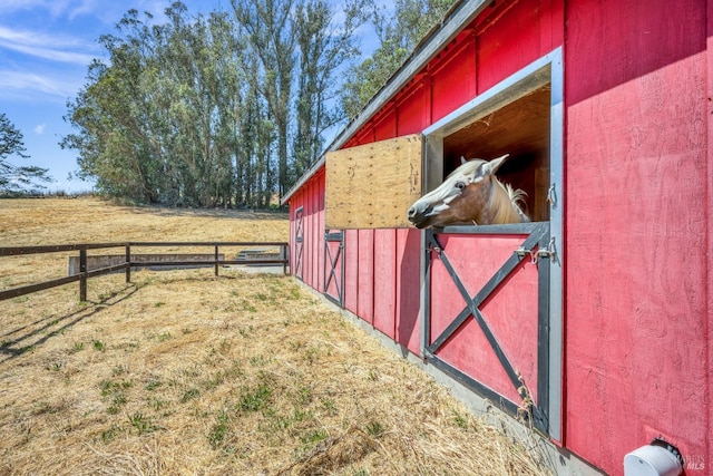 view of horse barn featuring a rural view