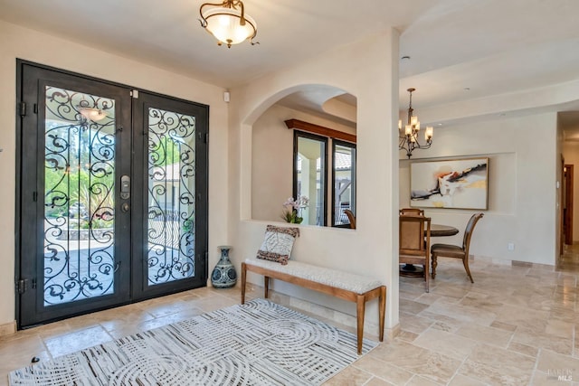 foyer featuring french doors and a notable chandelier