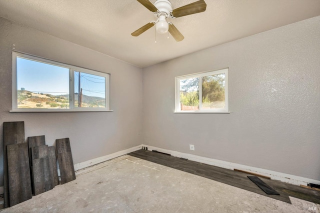 spare room with ceiling fan and baseboards