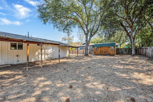 view of yard with a storage shed, an outbuilding, and a fenced backyard