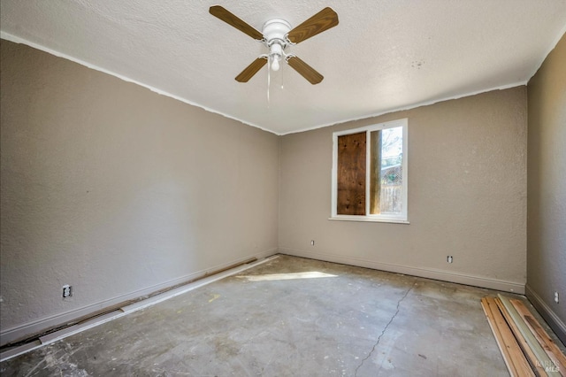 unfurnished room with a textured wall, ceiling fan, a textured ceiling, concrete floors, and baseboards