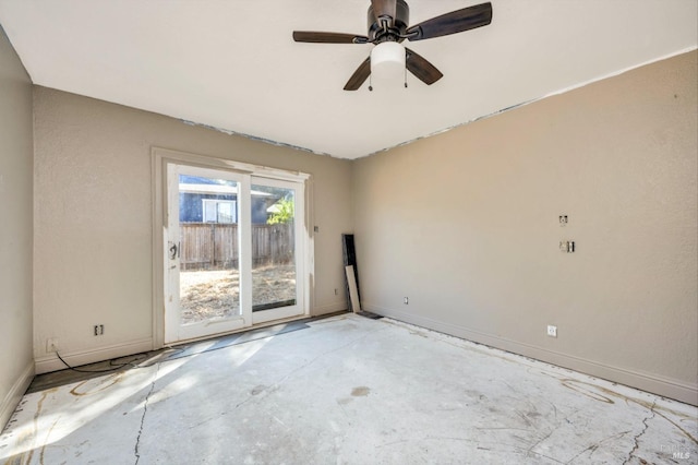 spare room featuring a ceiling fan, baseboards, and concrete flooring