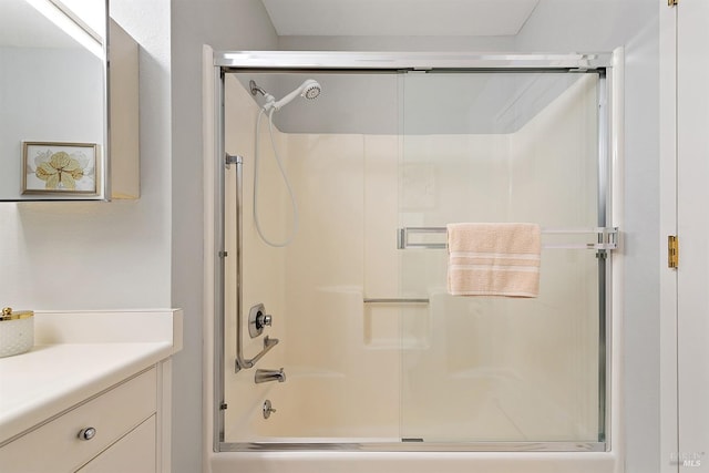 bathroom with bath / shower combo with glass door and vanity