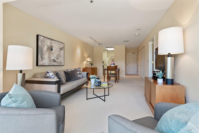 carpeted living room with rail lighting