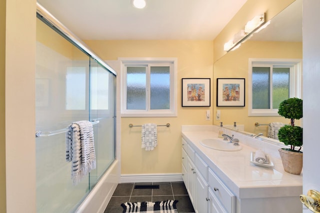 bathroom with vanity, bath / shower combo with glass door, tile patterned floors, and a healthy amount of sunlight