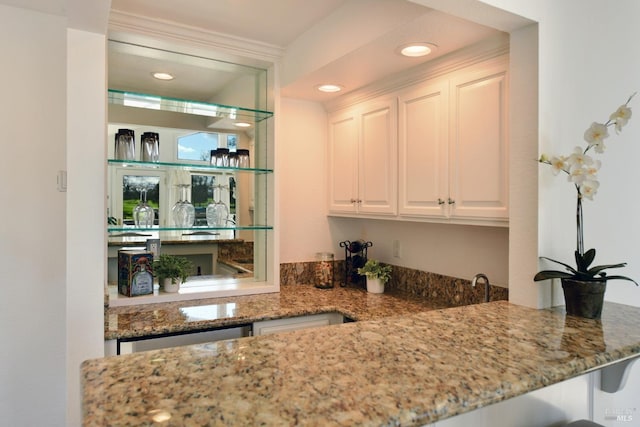 bar featuring stone counters, white cabinetry, and dishwasher