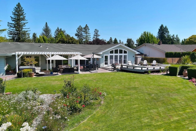 back of property featuring a wooden deck, a yard, and an outdoor hangout area