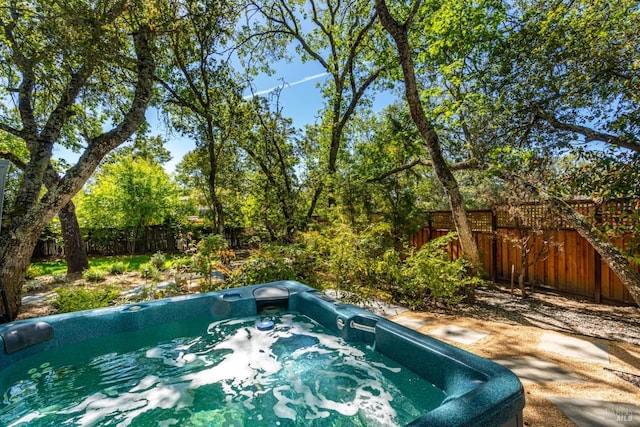 view of pool with a hot tub and a fenced backyard
