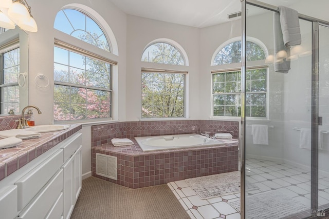 bathroom with tile patterned floors, separate shower and tub, and vanity