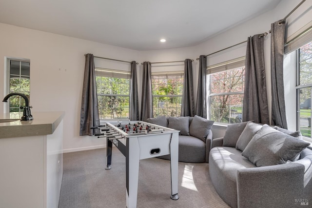 playroom with carpet floors, a wealth of natural light, a sink, and baseboards