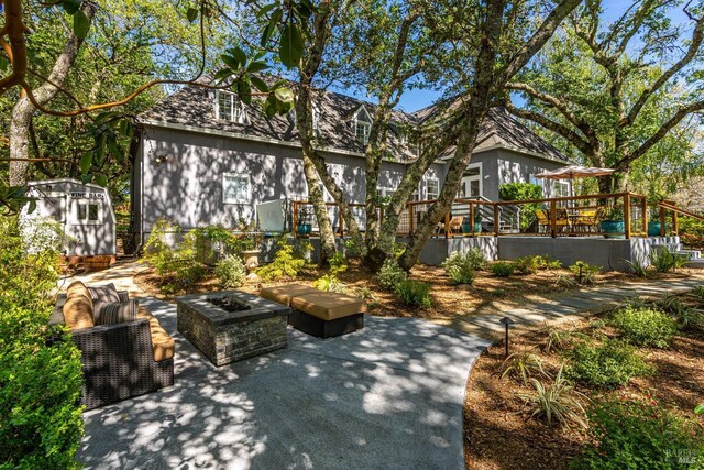 exterior space featuring an outdoor fire pit and a wooden deck