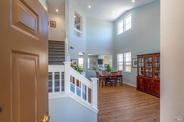 stairway featuring wood-type flooring and a towering ceiling