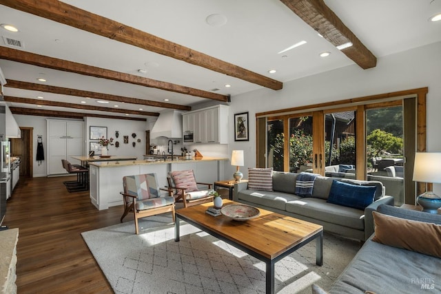 living room featuring plenty of natural light, beamed ceiling, and dark hardwood / wood-style flooring