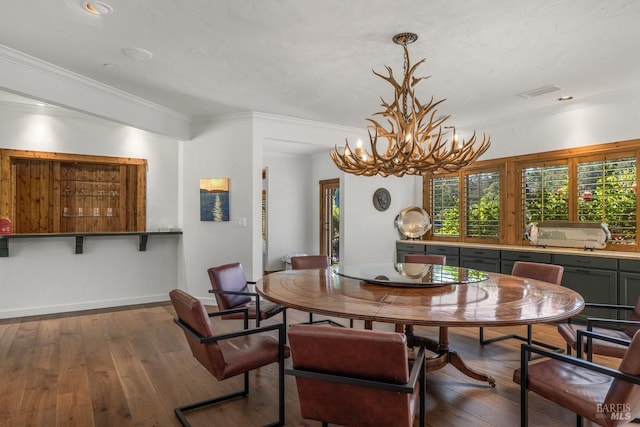 dining room with plenty of natural light, crown molding, an inviting chandelier, and hardwood / wood-style flooring