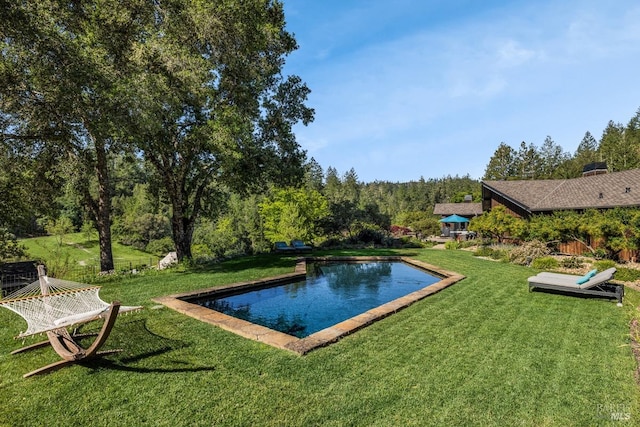 view of pool with a lawn