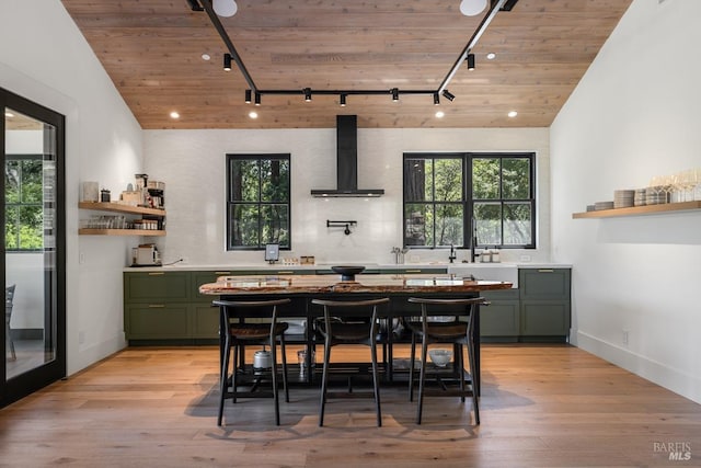 kitchen featuring track lighting, light hardwood / wood-style floors, wall chimney exhaust hood, and wooden ceiling