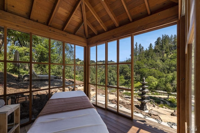 sunroom / solarium with a wealth of natural light, vaulted ceiling with beams, and wood ceiling