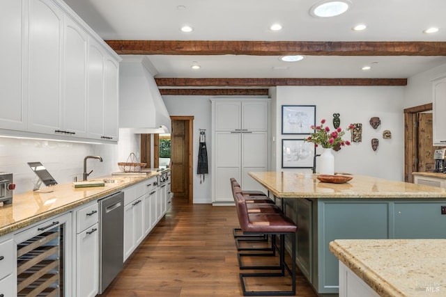 kitchen featuring white cabinetry, wine cooler, a center island, light stone countertops, and hardwood / wood-style flooring