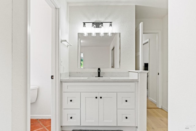 bathroom featuring tile patterned floors, vanity, and toilet