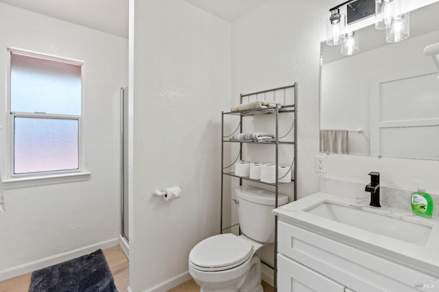 bathroom featuring toilet, vanity, a shower with shower door, and hardwood / wood-style flooring