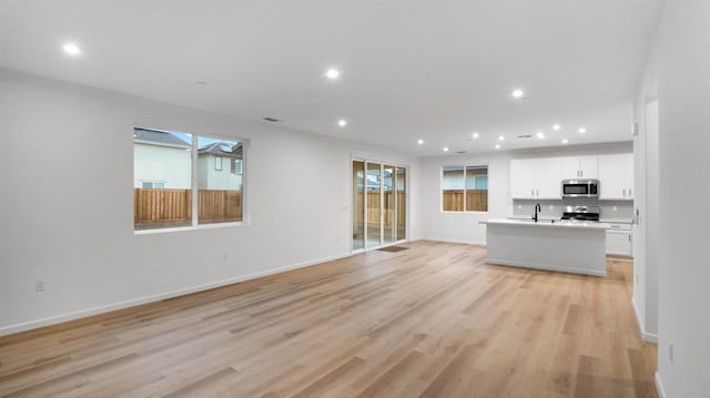 unfurnished living room with light wood-type flooring and sink