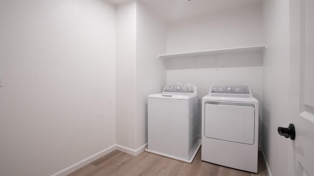 clothes washing area featuring washing machine and dryer and light wood-type flooring