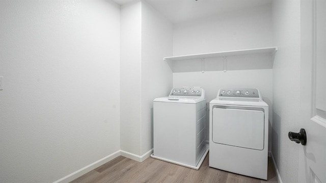 clothes washing area with light wood-type flooring and independent washer and dryer