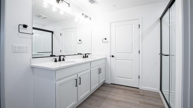 bathroom featuring vanity, hardwood / wood-style floors, and a shower with shower door