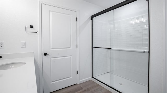 bathroom featuring an enclosed shower, hardwood / wood-style floors, and sink