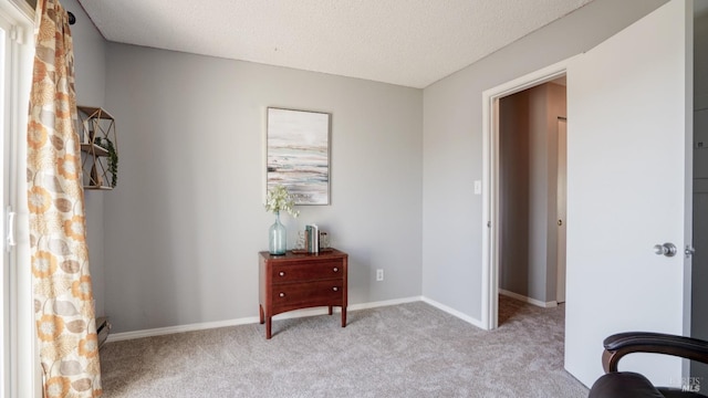 interior space with a baseboard heating unit, baseboards, carpet floors, and a textured ceiling