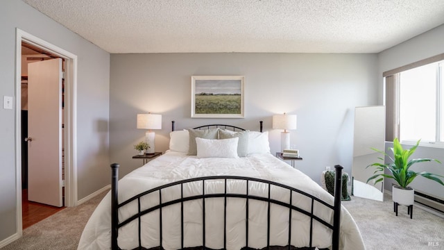 carpeted bedroom featuring baseboards and a textured ceiling