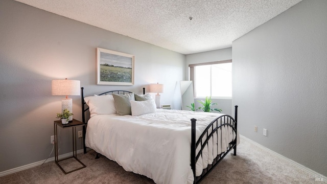 carpeted bedroom with a textured wall, baseboards, and a textured ceiling