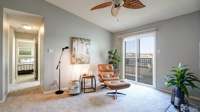 sitting room with baseboards, lofted ceiling, carpet floors, a textured ceiling, and a ceiling fan